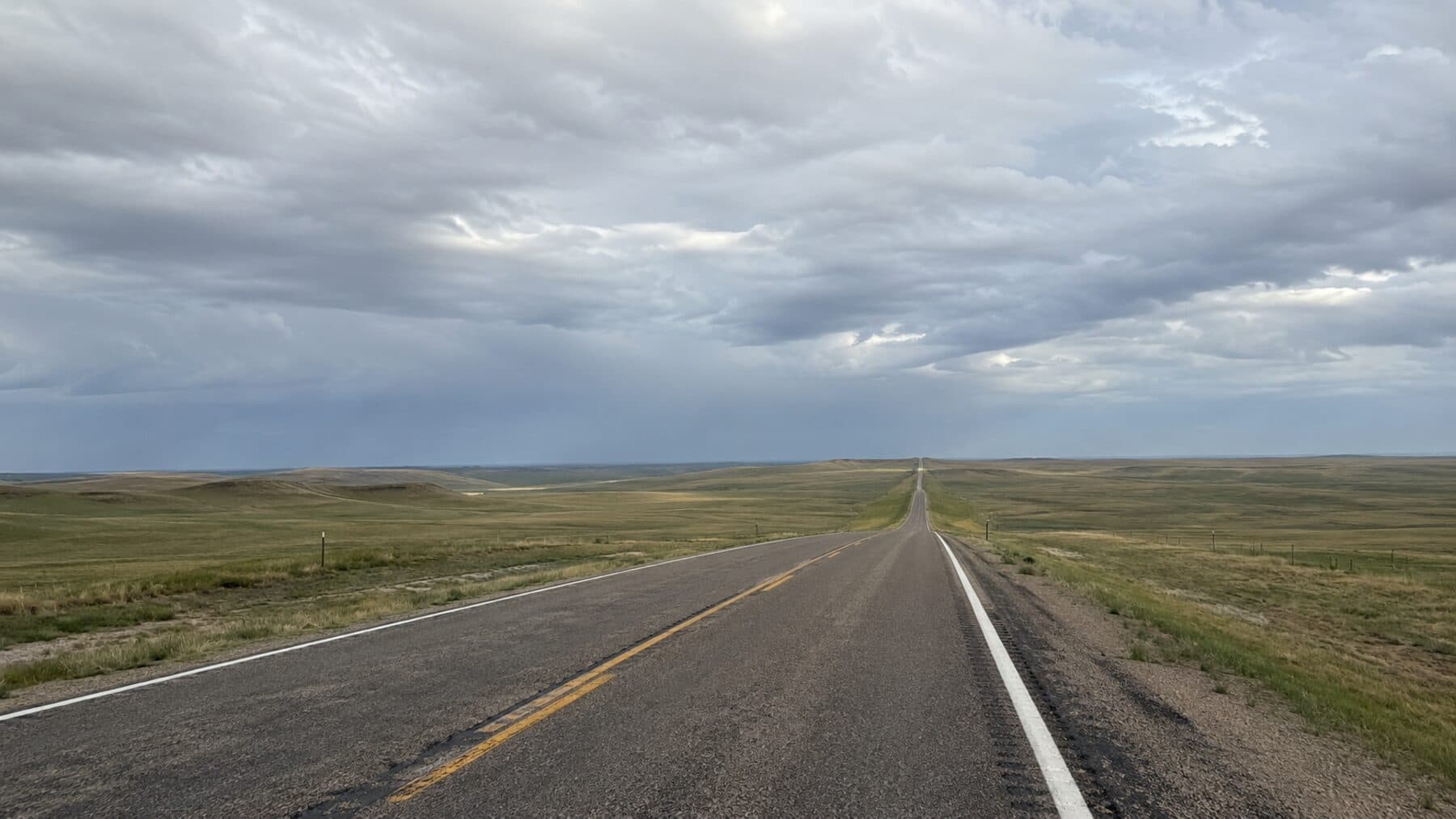 A two-lane road running through open prairie